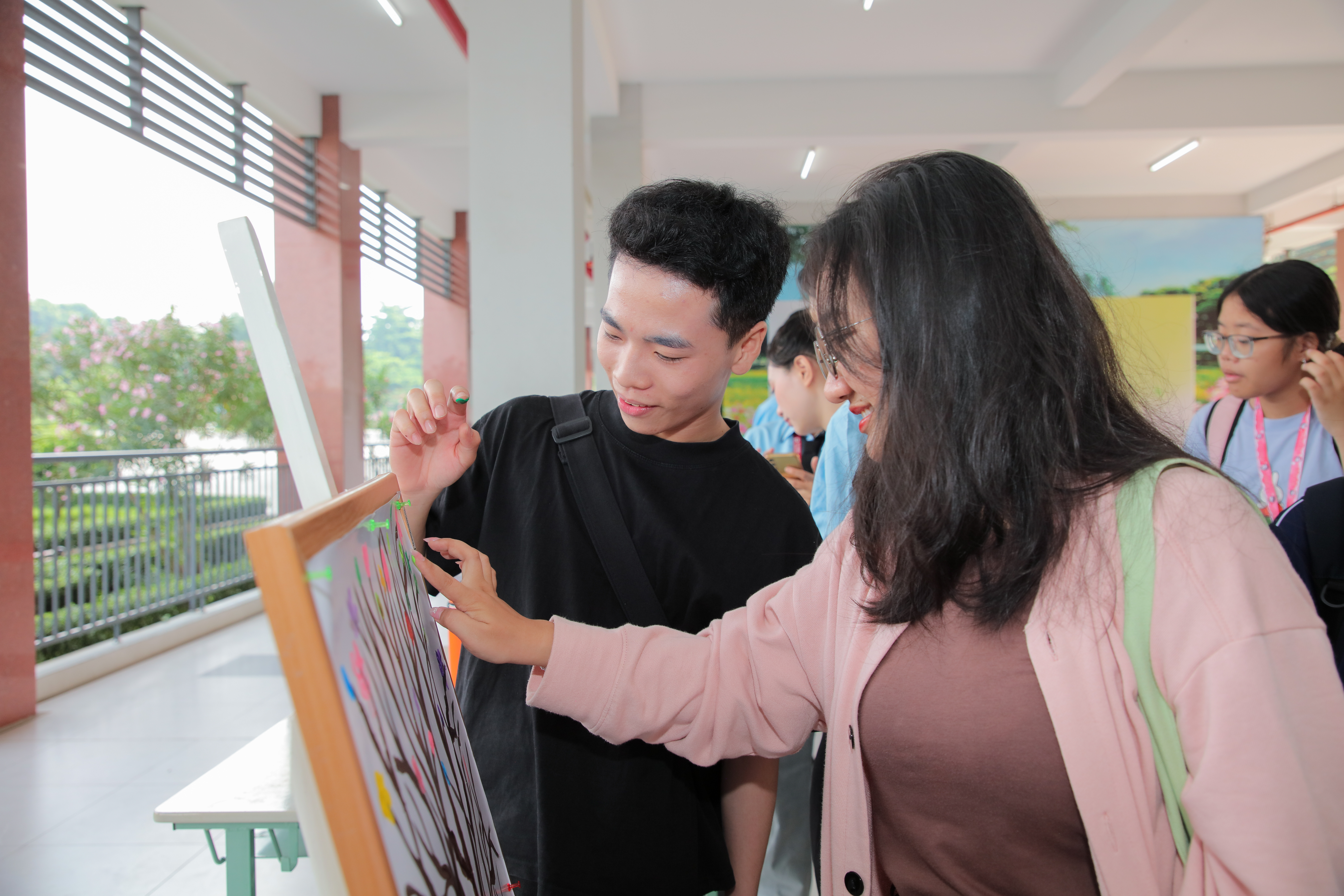 Các sinh viên thực hiện in dấu vân tay lên sản phẩm “cây cam kết” của chương trình, thể hiện lời hứa hành động vì một môi trường bền vững. Ảnh: Lý Nguyên.
