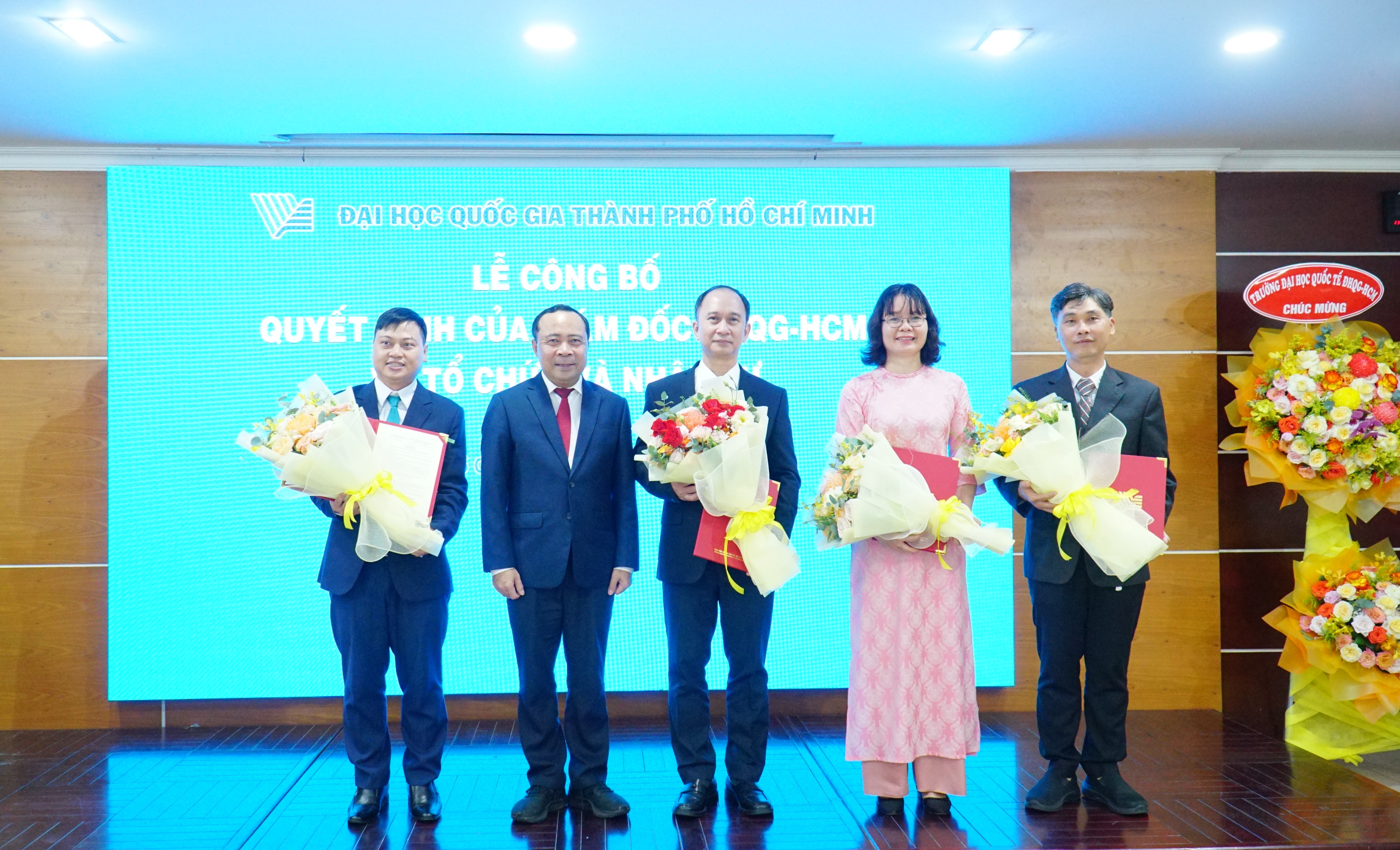 PGS.TS Vũ Hải Quân trao quyết định và hoa chúc mừng cho lãnh đạo Viện Công nghệ Vật liệu tiên tiến ĐHQG-HCM.